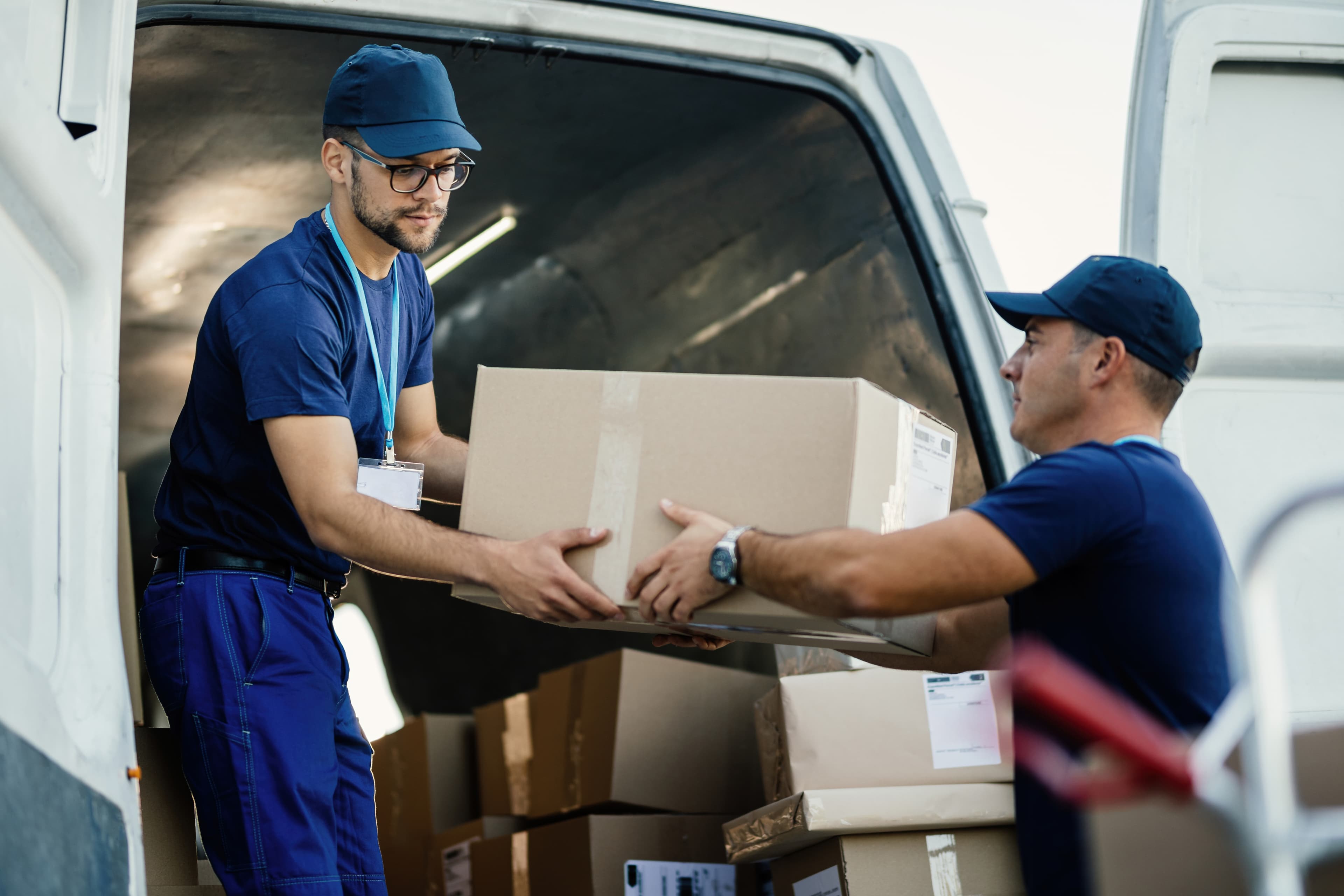 Relocation specialists carefully handling boxed household goods for white-glove moving